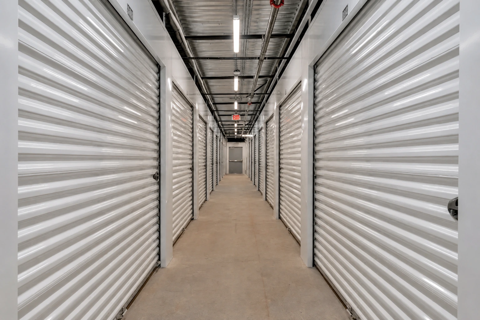 Finished interior hallway with white roll-up doors at Timp Highway Self Storage